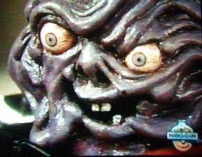 An image of Gooey Gus from the Ghostwriter TV show, a frightening purple monster with bulbous eyes and a head that looks like melted chewing gum.